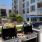 Apartments In Nob Hill, San Francisco, CA - Etta - Grill Area With BBQs, Shaded Lounged Area, Large Jenga With Table And Seating, Lush Greens, And Patio Furniture.