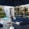 Pet-Friendly Apartments in San Francisco CA - Etta - Outdoor Lounge Area Features a Large Couch and Extra Chairs Surrounding a Fireplace.